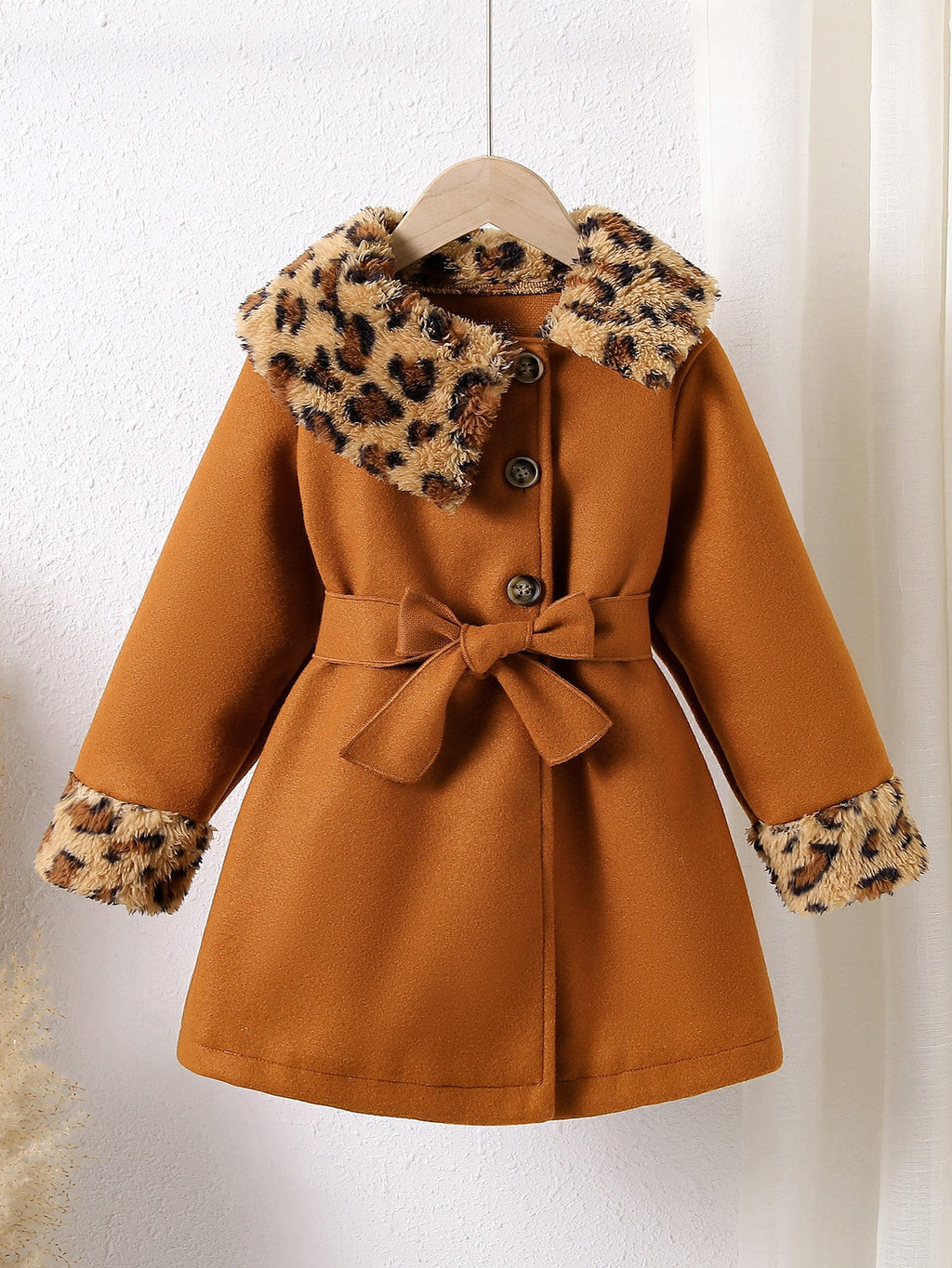 Abrigo de terciopelo suave con toque cálido y detalles de piel estampada.