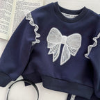 Conjunto de 2 piezas: sudadera con lazo destacado y falda integrada con pantalón.