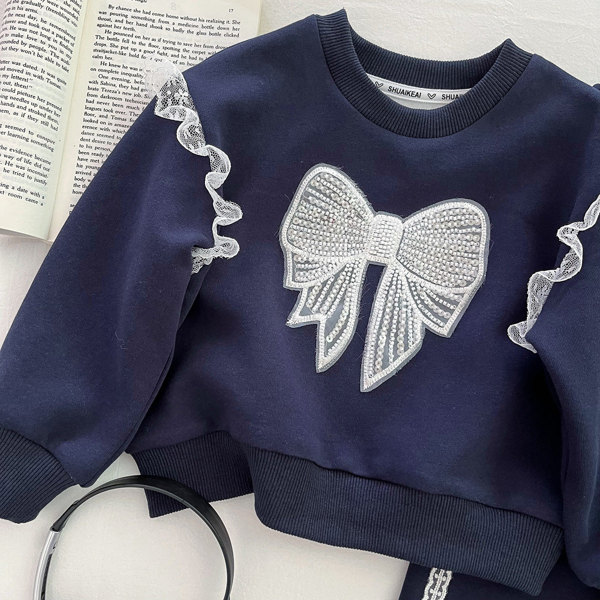 Conjunto de 2 piezas: sudadera con lazo destacado y falda integrada con pantalón.