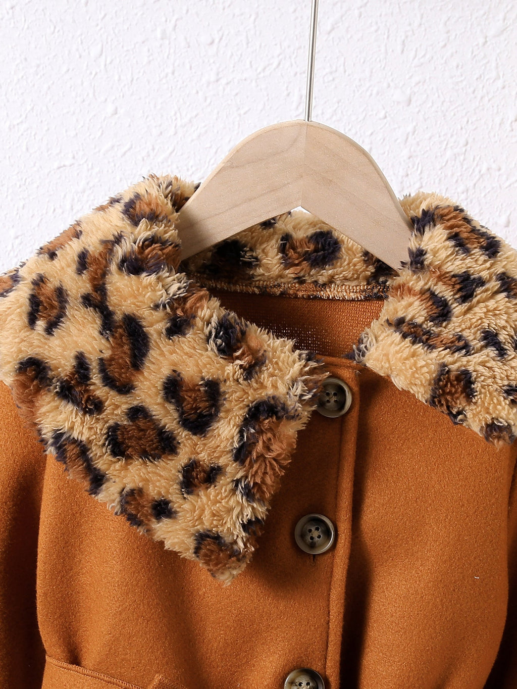 Abrigo de terciopelo suave con toque cálido y detalles de piel estampada.