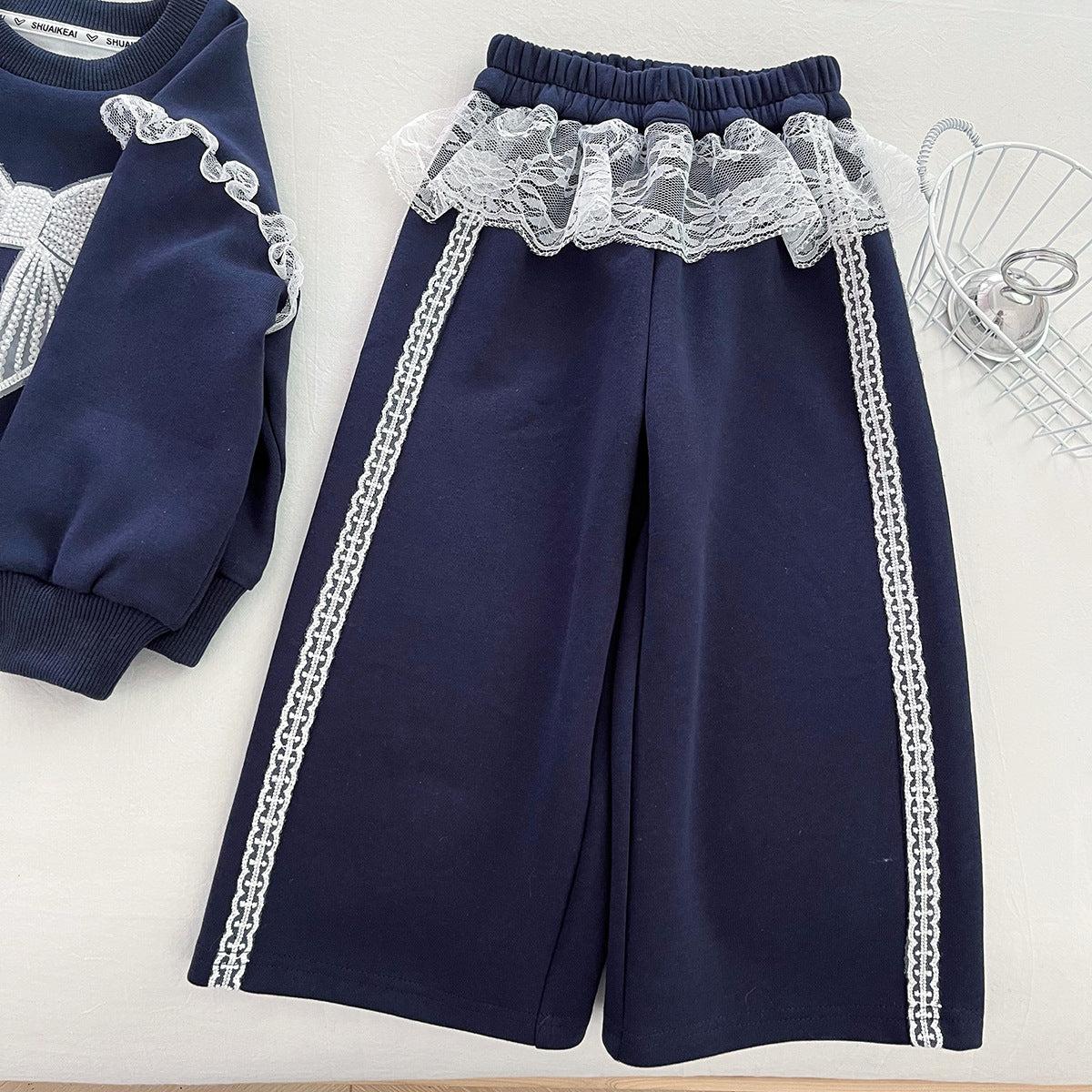 Conjunto de 2 piezas: sudadera con lazo destacado y falda integrada con pantalón.