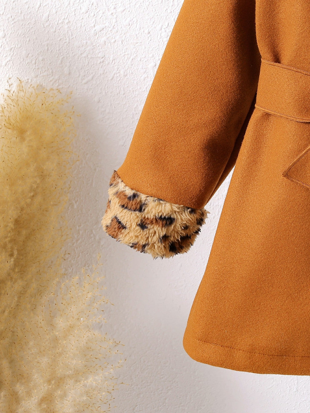 Abrigo de terciopelo suave con toque cálido y detalles de piel estampada.