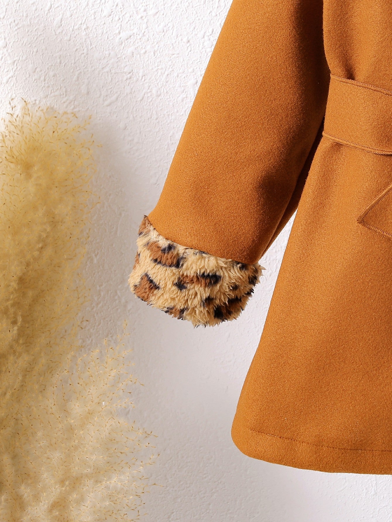 Abrigo de terciopelo suave con toque cálido y detalles de piel estampada.